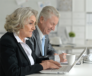 Ageing workforce – two mature workers at computers