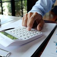 Man using calculator to work out finances for reverse VAT charge