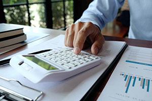 Man using calculator to work out finances for reverse VAT charge