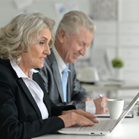 Ageing workforce – two mature workers at computers 