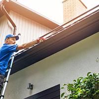 Tradesperson cleaning gutters